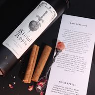 Gros plan de l'étiquette de la bougie Sinful Apple avec athamé et motif de pomme